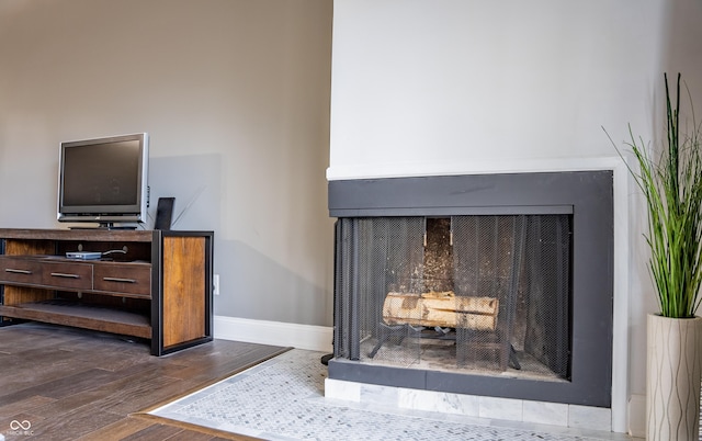 room details with hardwood / wood-style flooring and a tiled fireplace