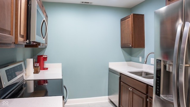 kitchen featuring sink, light tile patterned flooring, and stainless steel appliances