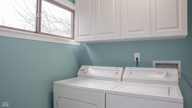 washroom featuring washer and clothes dryer and cabinets