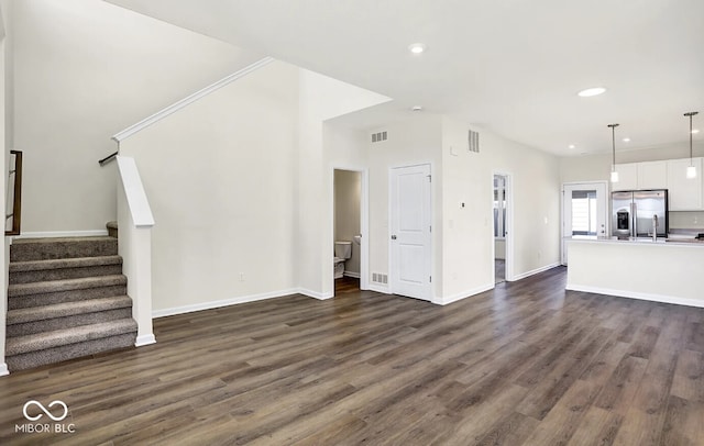 unfurnished living room with dark hardwood / wood-style floors and sink