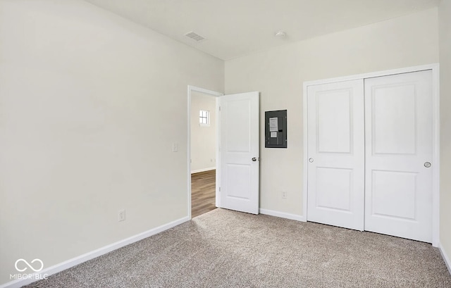 unfurnished bedroom featuring carpet, a closet, and electric panel