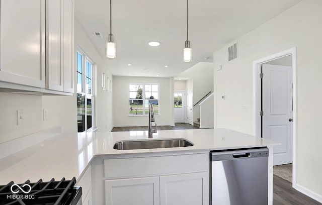 kitchen with dishwasher, white cabinetry, hanging light fixtures, and sink