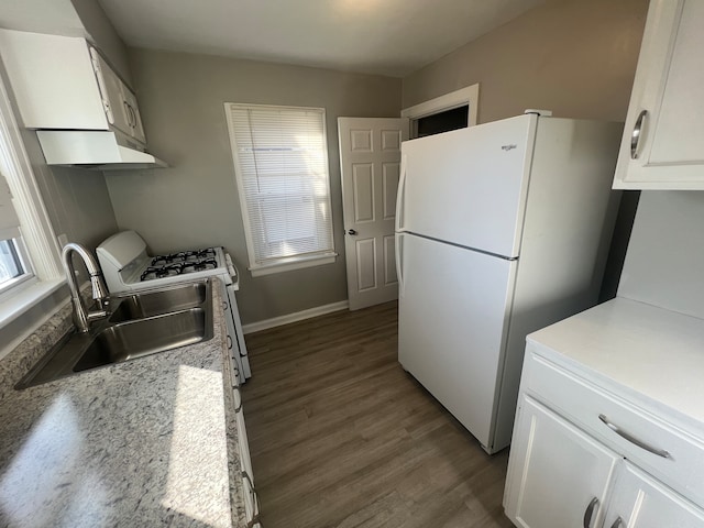 kitchen with white cabinets, white appliances, hardwood / wood-style floors, and sink