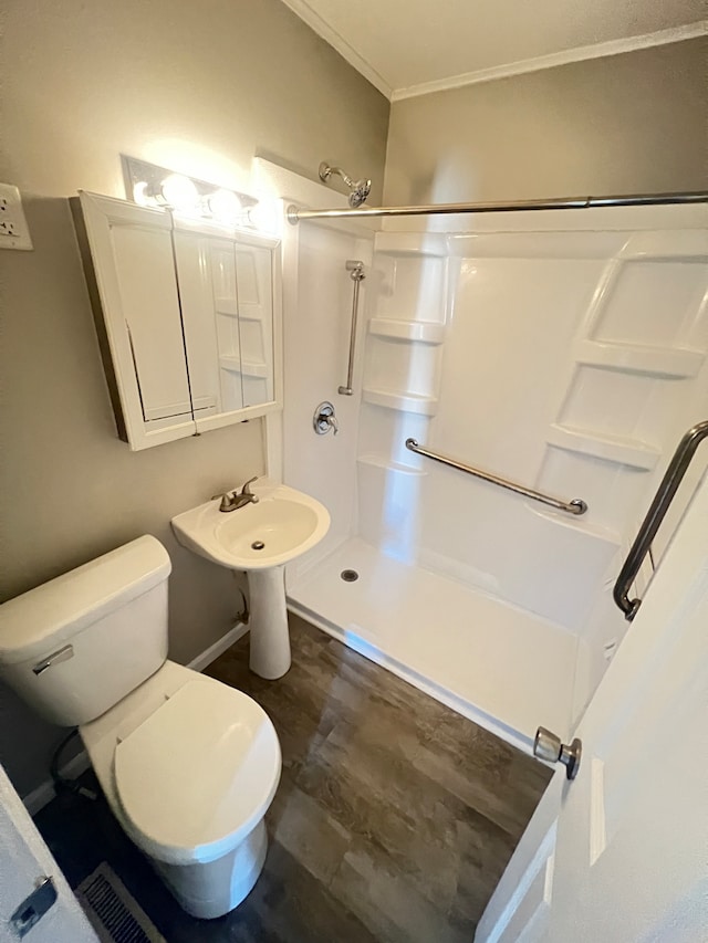 bathroom with walk in shower, hardwood / wood-style flooring, crown molding, and toilet