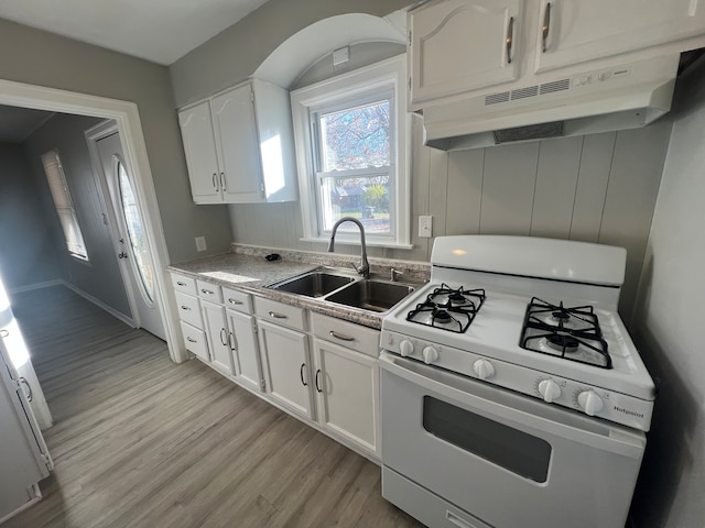 kitchen featuring sink, gas range gas stove, white cabinetry, and light hardwood / wood-style flooring