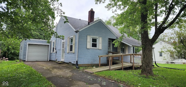 view of front of property featuring a garage, a wooden deck, and a front yard