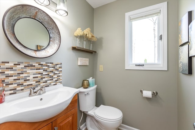 bathroom featuring oversized vanity, tasteful backsplash, and toilet