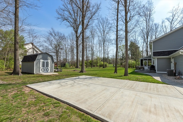 view of yard with central AC unit and a shed