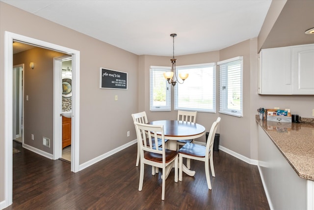 dining area with dark hardwood / wood-style floors and a notable chandelier