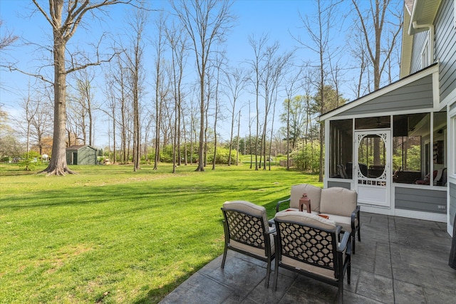 view of yard with a patio area, a sunroom, and a storage shed