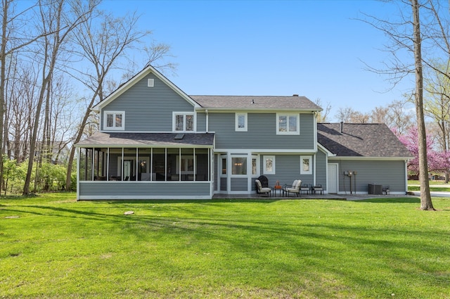 rear view of property with a sunroom and a lawn