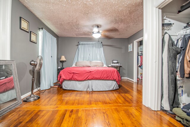 2925 Highwoods Dr, Indianapolis, IN 46222 - bedroom with baseboards, ceiling fan, a textured ceiling, and wood finished floors