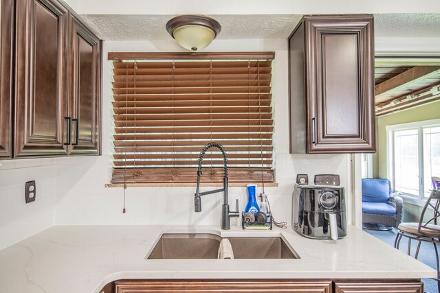 2925 Highwoods Dr, Indianapolis, IN 46222 - kitchen featuring a sink, a textured ceiling, and dark brown cabinetry