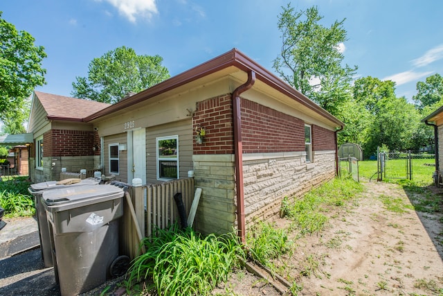 2925 Highwoods Dr, Indianapolis, IN 46222 - view of home's exterior with fence, a gate, and brick siding
