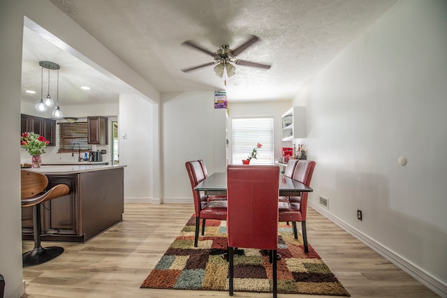 2925 Highwoods Dr, Indianapolis, IN 46222 - dining space featuring a textured ceiling, ceiling fan, baseboards, and light wood-type flooring