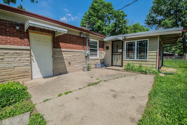 2925 Highwoods Dr, Indianapolis, IN 46222 - entrance to property featuring fence, stone siding, and brick siding
