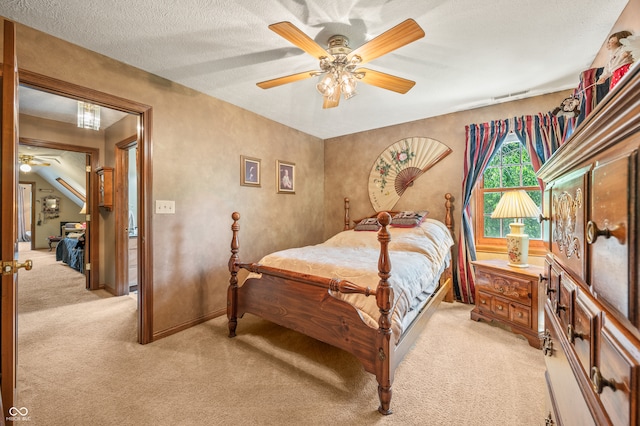 carpeted bedroom featuring ceiling fan and a textured ceiling