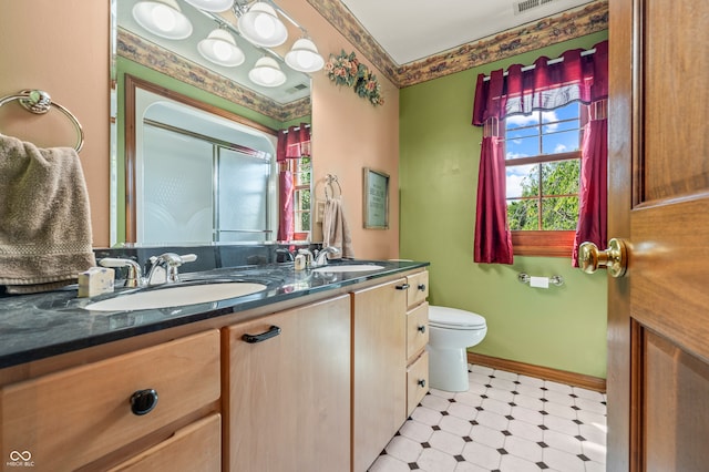 bathroom with tile flooring, toilet, and double vanity