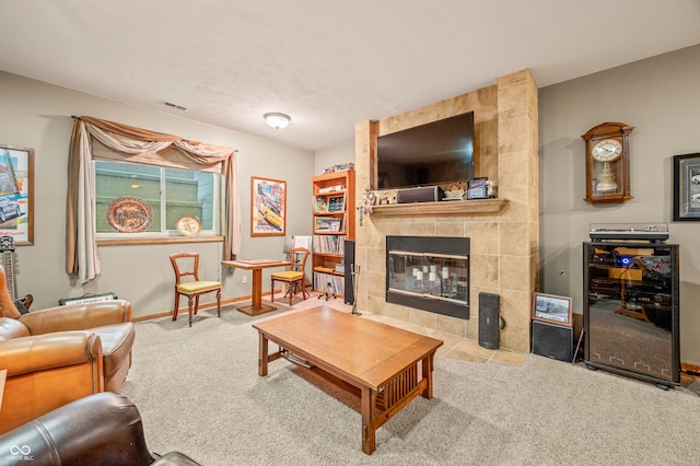 living room with carpet, a tiled fireplace, and tile walls