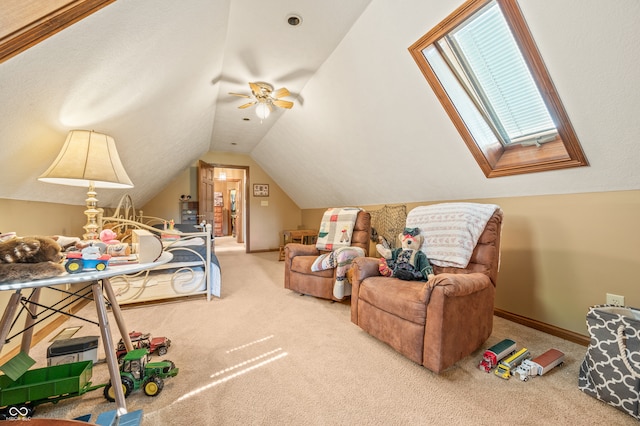 interior space featuring ceiling fan, carpet floors, and lofted ceiling with skylight