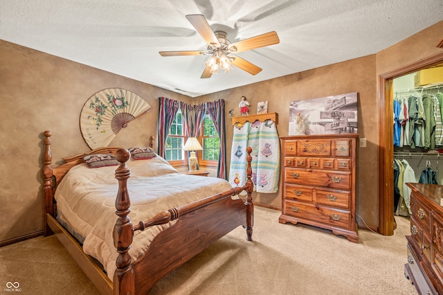 bedroom featuring a textured ceiling, a closet, carpet, and ceiling fan