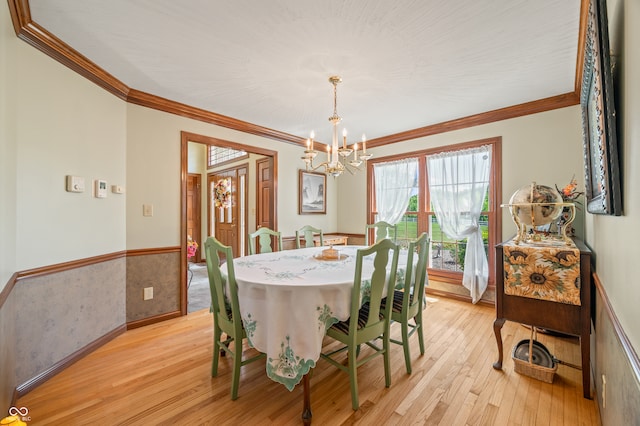 dining space featuring a chandelier, light hardwood / wood-style flooring, and ornamental molding