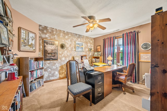 carpeted office space featuring a textured ceiling and ceiling fan