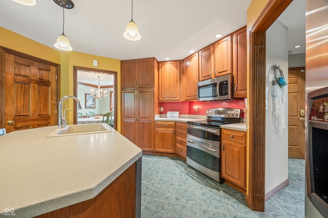 kitchen with stainless steel appliances, pendant lighting, tile floors, sink, and a kitchen island with sink