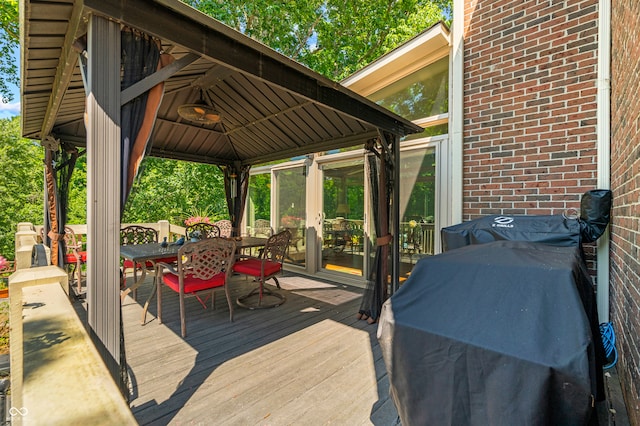 wooden deck with a gazebo and a grill