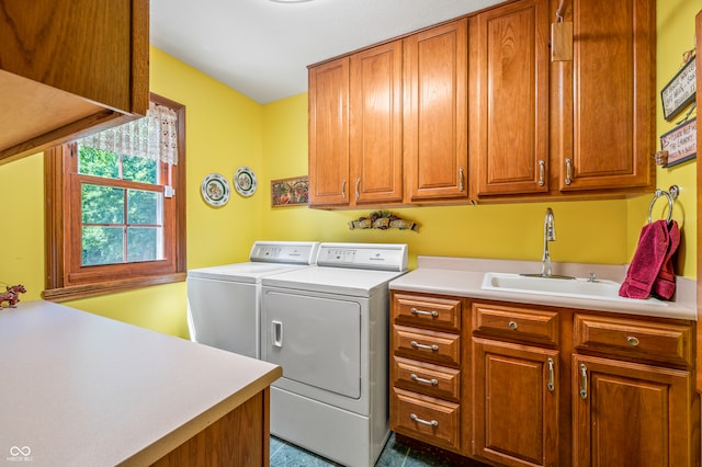 clothes washing area featuring cabinets, sink, and washing machine and dryer