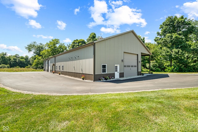 view of shed / structure with a garage and a yard