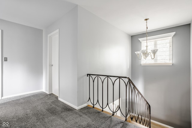 stairs featuring a notable chandelier and carpet floors