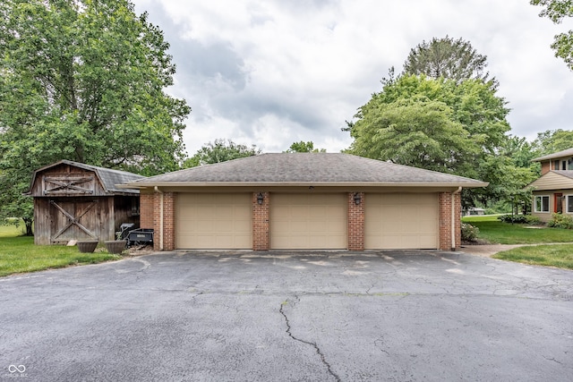 view of front of property with a garage and an outbuilding