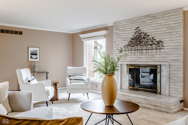 sitting room with a wealth of natural light, a large fireplace, and crown molding