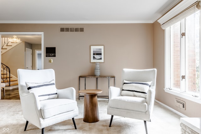 living area with light carpet, crown molding, and an inviting chandelier