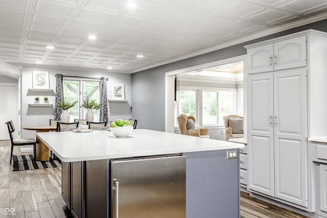 kitchen with hardwood / wood-style floors, white cabinetry, fridge, and a kitchen island