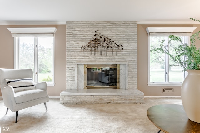 living area featuring carpet, a large fireplace, and crown molding