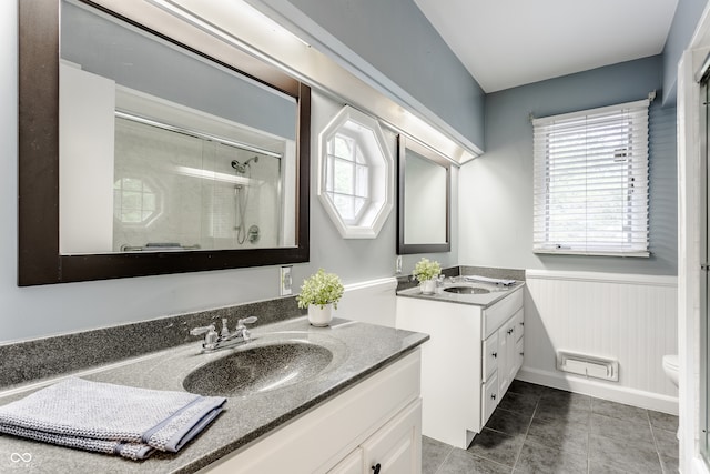 bathroom with tile patterned floors, vanity, toilet, and walk in shower