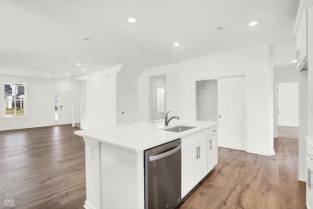 kitchen with hardwood / wood-style floors, white cabinetry, dishwasher, an island with sink, and sink