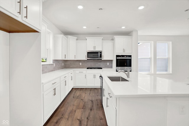 kitchen with white cabinetry, stainless steel appliances, sink, and dark hardwood / wood-style floors