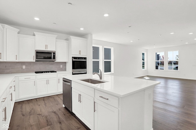 kitchen featuring a kitchen island with sink, white cabinetry, light hardwood / wood-style flooring, stainless steel appliances, and sink