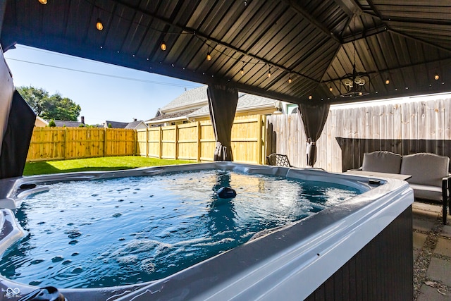 view of swimming pool featuring a gazebo and a hot tub