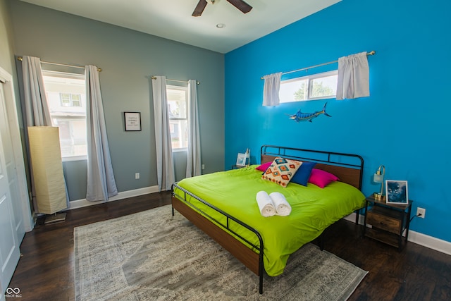 bedroom with multiple windows, ceiling fan, and wood-type flooring