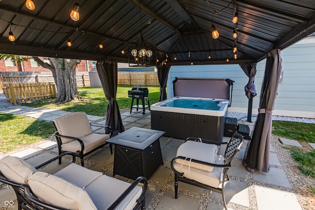 view of patio / terrace with a gazebo, a hot tub, and an outdoor living space