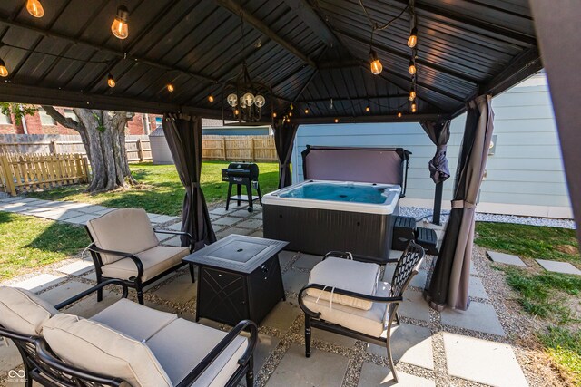 view of patio featuring a gazebo, a hot tub, and an outdoor hangout area