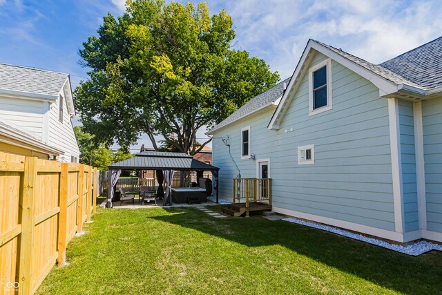 rear view of house with a gazebo, a patio, and a lawn