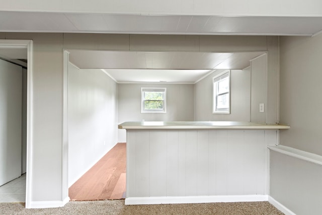 kitchen featuring kitchen peninsula and light colored carpet