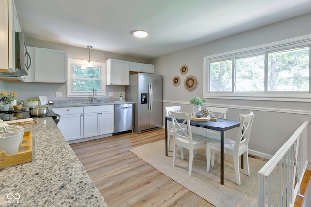 kitchen featuring white cabinets, sink, stainless steel appliances, and light hardwood / wood-style floors