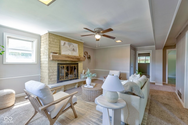 living room featuring ceiling fan, a healthy amount of sunlight, light colored carpet, and a brick fireplace