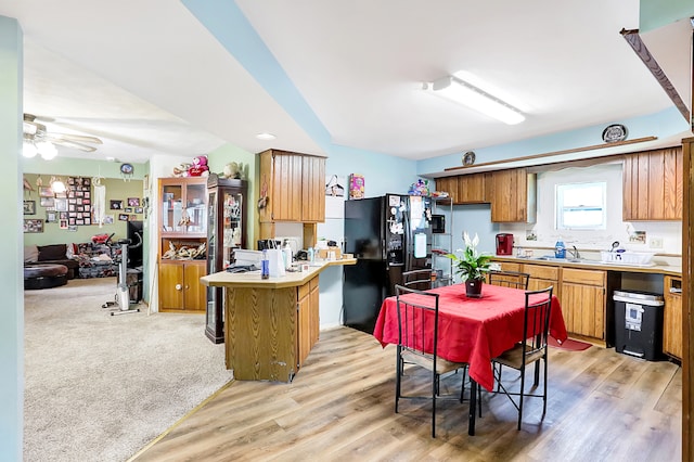 kitchen with ceiling fan, black refrigerator with ice dispenser, and light colored carpet